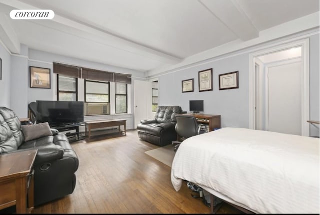 bedroom with beamed ceiling and hardwood / wood-style floors