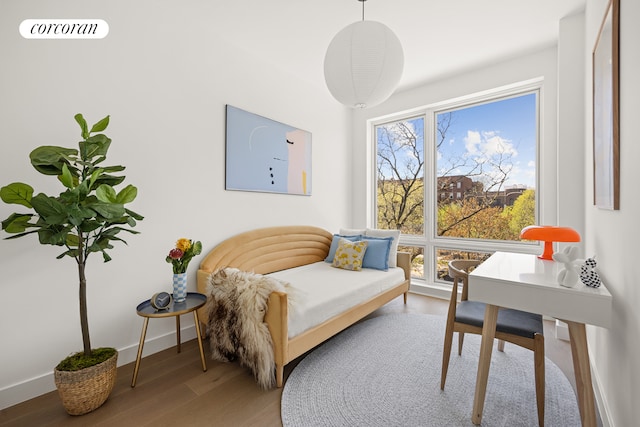 sitting room with wood finished floors, visible vents, and baseboards