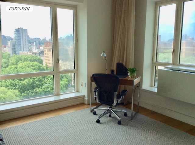 home office with baseboard heating and wood-type flooring