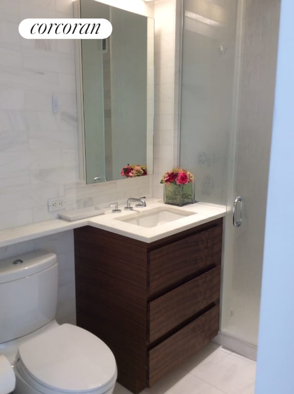 bathroom with toilet, vanity, and tile patterned flooring