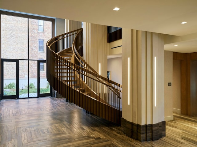 stairs featuring expansive windows and parquet floors