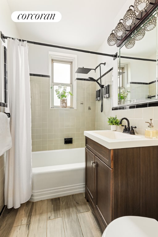 full bathroom with tasteful backsplash, shower / tub combo with curtain, vanity, and toilet