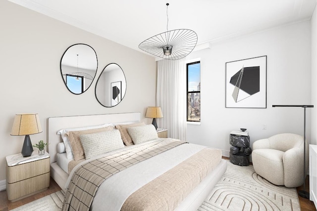 bedroom with crown molding and hardwood / wood-style flooring