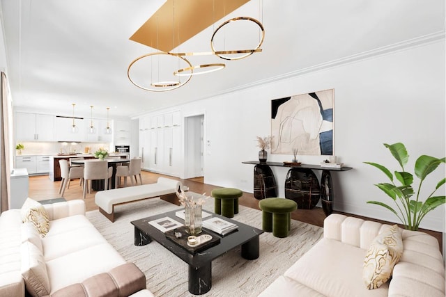 living room featuring a notable chandelier, ornamental molding, and light hardwood / wood-style floors