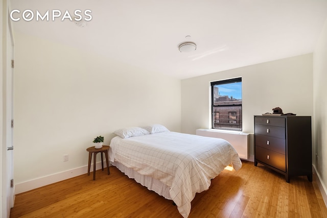 bedroom with light wood finished floors and baseboards