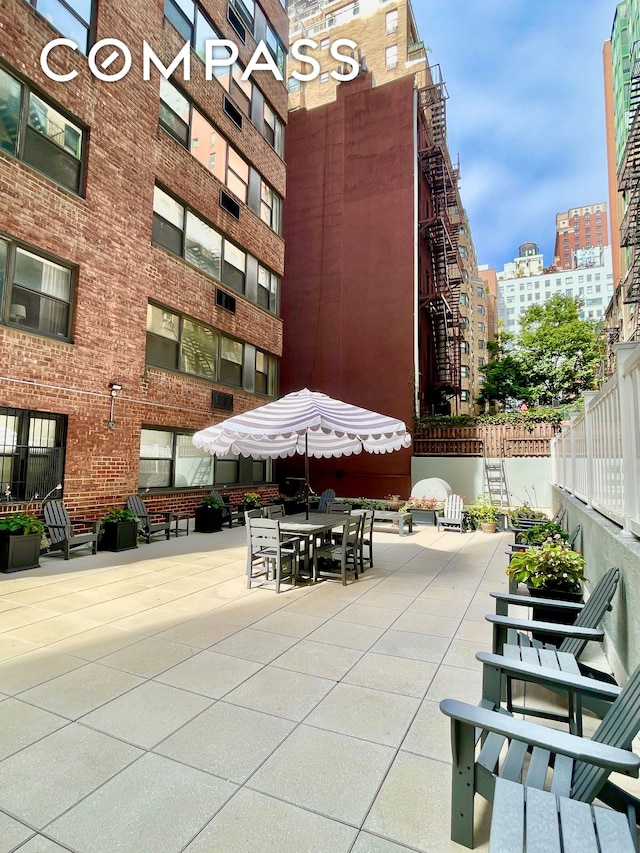 exterior space with a view of city, a patio, and fence