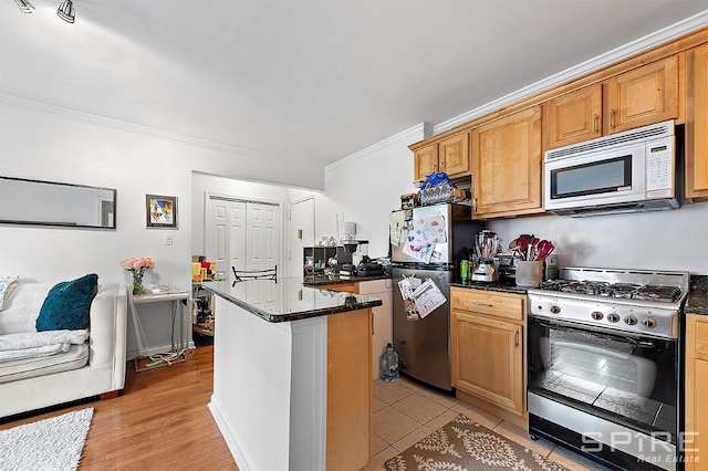 kitchen with light wood finished floors, dark stone counters, appliances with stainless steel finishes, a center island, and crown molding