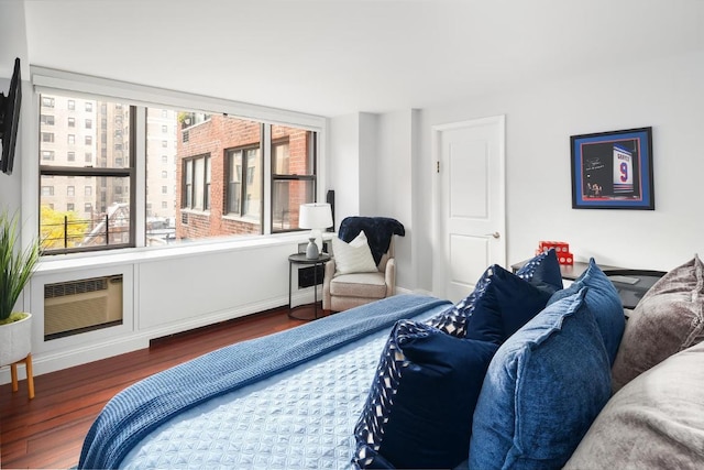 bedroom with dark hardwood / wood-style floors and a wall mounted air conditioner