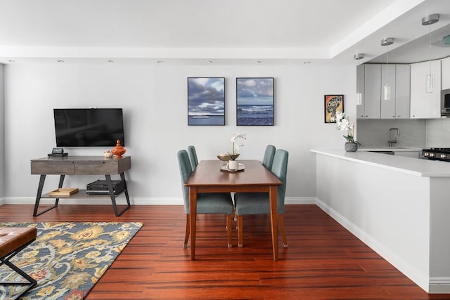 dining space featuring dark hardwood / wood-style floors and sink