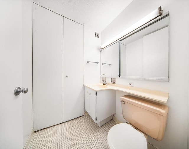 bathroom with vanity, a textured ceiling, and toilet