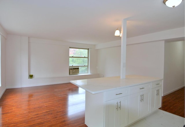 kitchen featuring light stone countertops, white cabinetry, light wood-type flooring, and a kitchen island