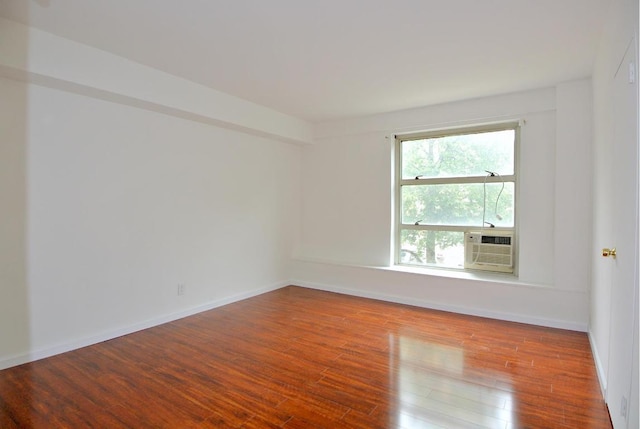 empty room featuring cooling unit and wood-type flooring