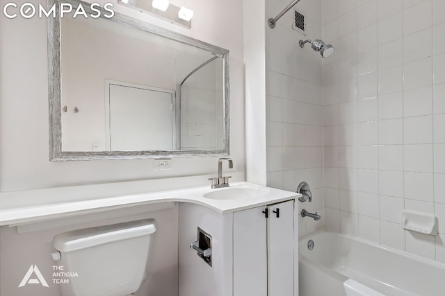 full bathroom featuring vanity, tiled shower / bath combo, and toilet