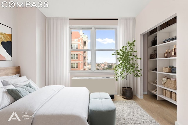 bedroom featuring wood-type flooring and radiator heating unit