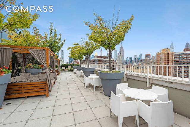 view of patio with a view of skyline, an outdoor hangout area, and a balcony
