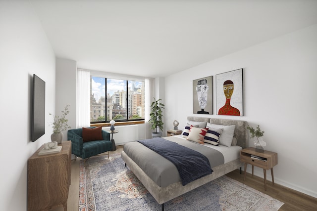 bedroom featuring baseboards and wood finished floors