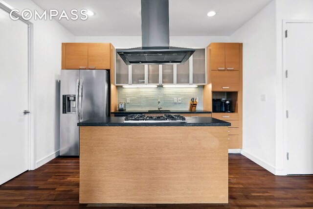 kitchen with dark wood-type flooring, appliances with stainless steel finishes, island range hood, and tasteful backsplash