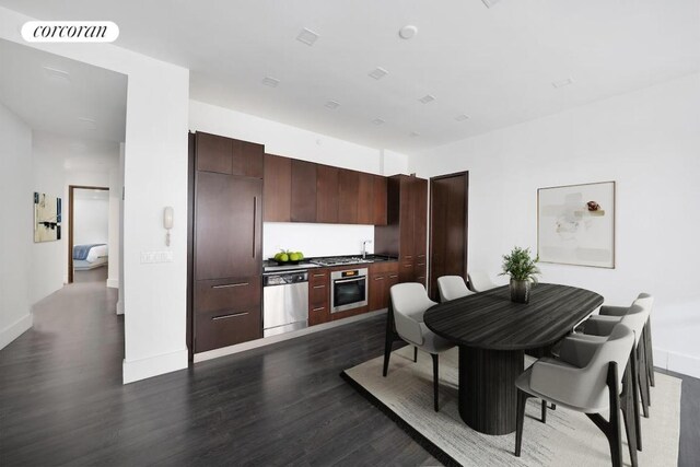 kitchen featuring dark hardwood / wood-style flooring, sink, dark brown cabinetry, and appliances with stainless steel finishes