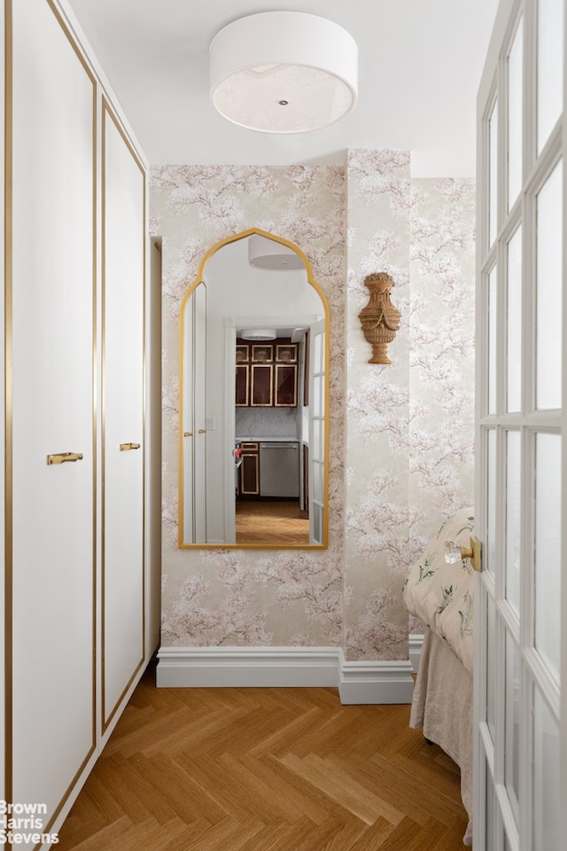 hall featuring baseboards and wallpapered walls