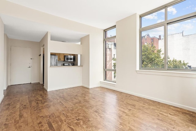 unfurnished living room with plenty of natural light and light hardwood / wood-style flooring