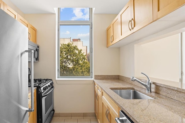 kitchen featuring light tile patterned flooring, stainless steel appliances, sink, and light brown cabinets