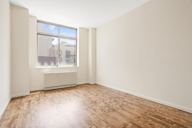 empty room with radiator and light wood-type flooring