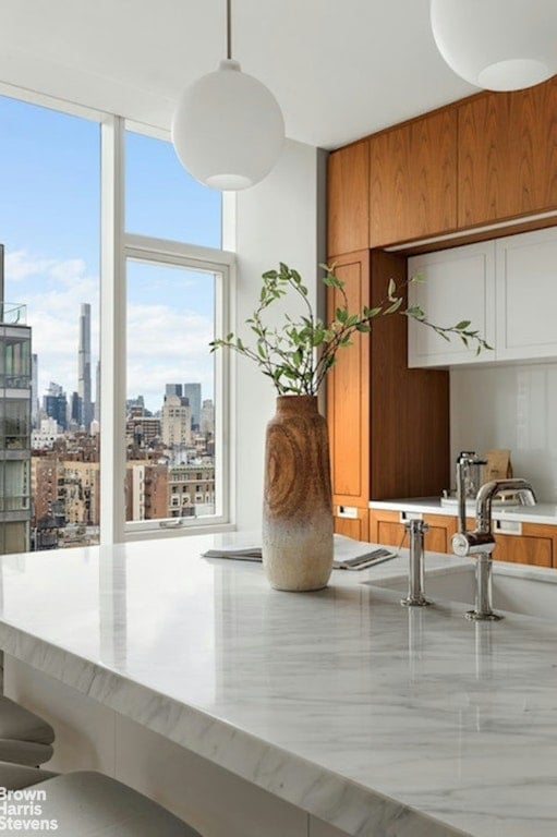 kitchen featuring sink, wood walls, and pendant lighting