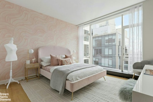 bedroom featuring light hardwood / wood-style flooring and expansive windows