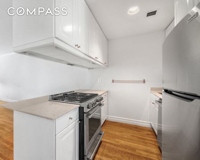 kitchen with white cabinetry, appliances with stainless steel finishes, baseboards, visible vents, and light wood-style floors