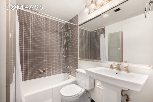 full bath featuring shower / tub combo, visible vents, and toilet