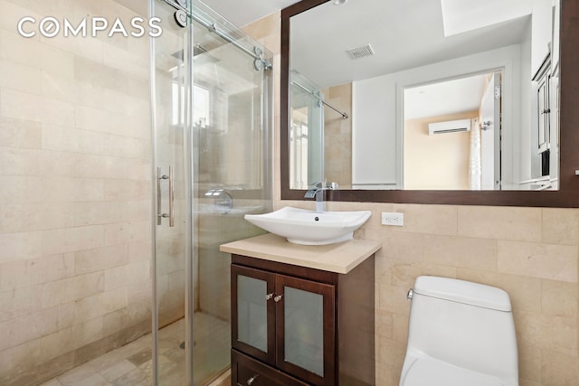 bathroom with an AC wall unit, vanity, a shower stall, and visible vents