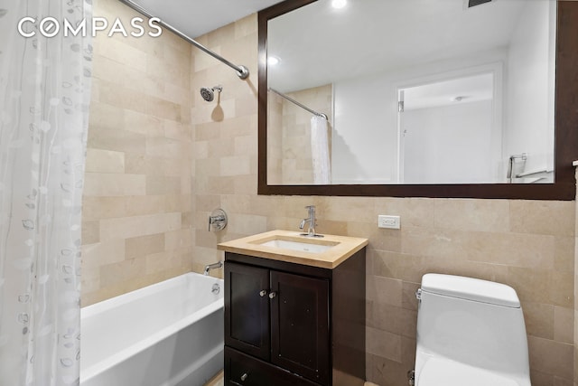 full bath featuring toilet, vanity, shower / bath combo with shower curtain, and tile walls