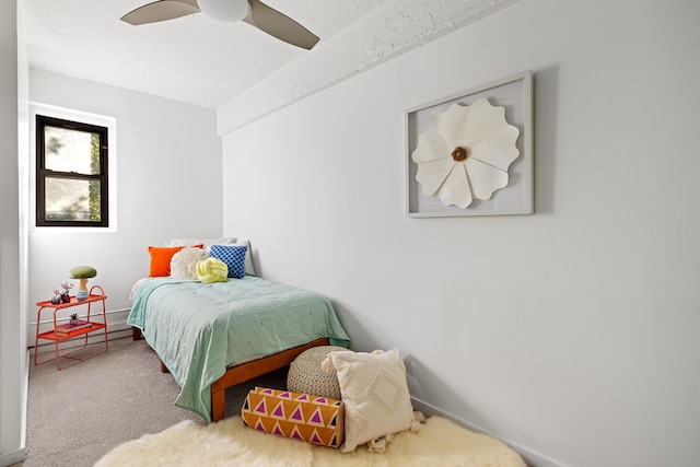 bedroom with a textured ceiling, ceiling fan, and carpet flooring