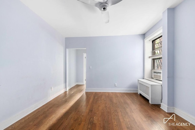 spare room with ceiling fan, cooling unit, wood-type flooring, and radiator heating unit