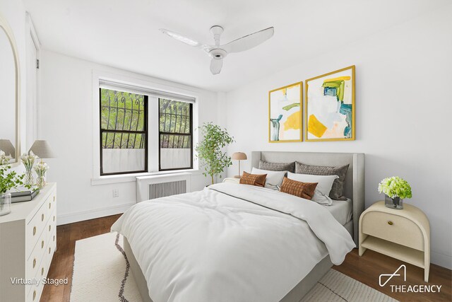 bedroom with ceiling fan, radiator, and dark hardwood / wood-style flooring