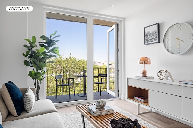 living room with a wall of windows, wood finished floors, and a wealth of natural light