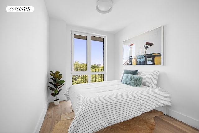 bedroom featuring visible vents, light wood-style flooring, and baseboards