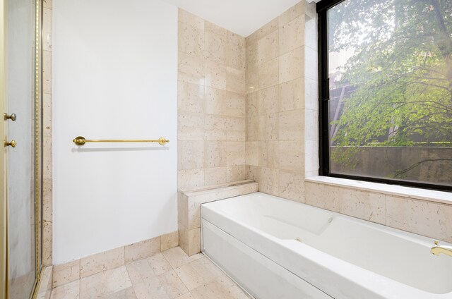 full bath featuring a bath and baseboards