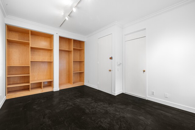 interior space featuring rail lighting, baseboards, and crown molding