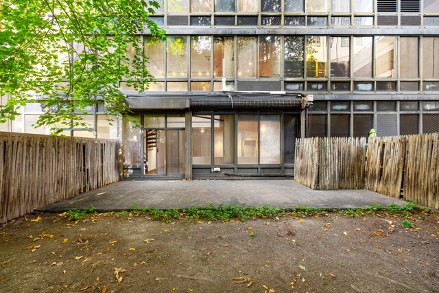 back of property featuring a patio and fence