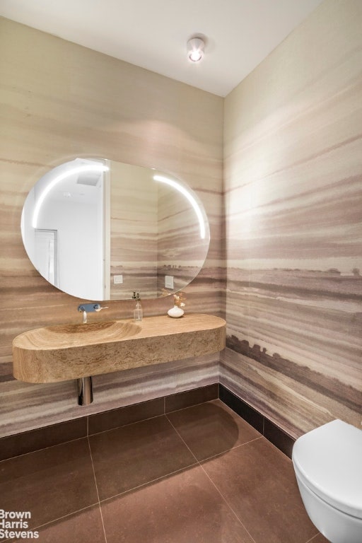 bathroom featuring toilet and tile patterned flooring