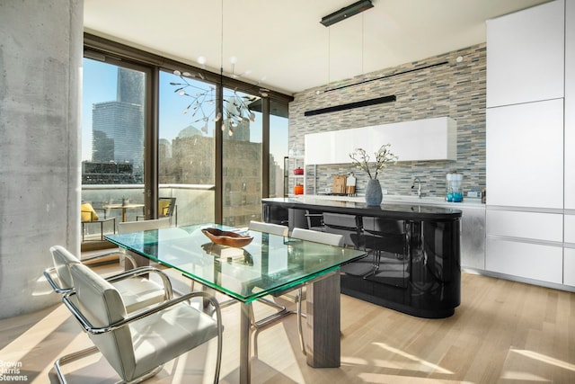 dining area featuring a view of city, expansive windows, and wood finished floors