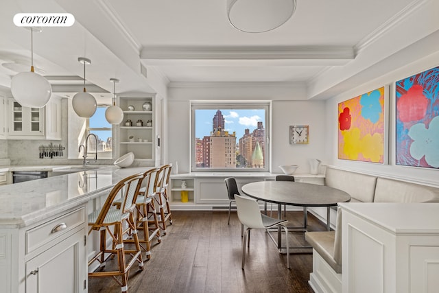 dining room featuring sink, crown molding, dark wood-type flooring, breakfast area, and built in shelves