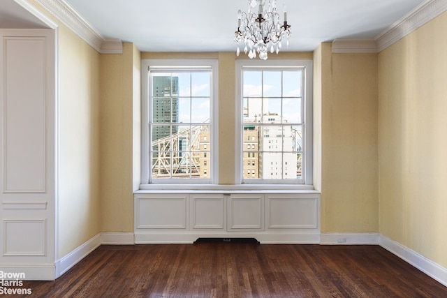 unfurnished dining area with dark wood-type flooring, a chandelier, ornamental molding, and baseboards