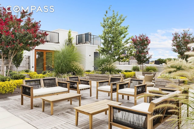 view of patio with a balcony, central AC unit, and an outdoor hangout area