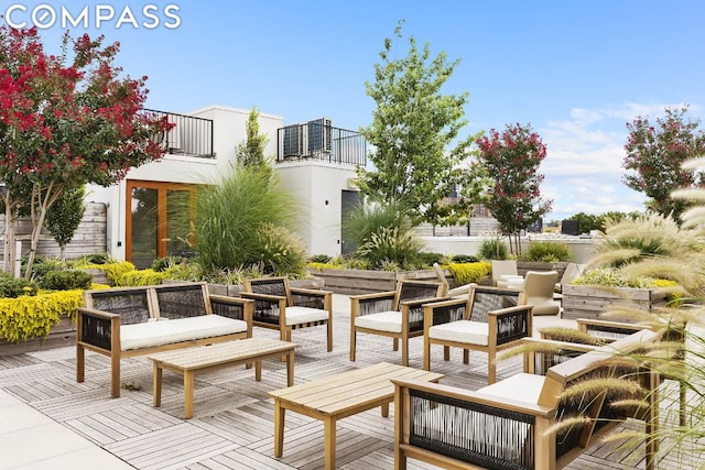 view of patio / terrace with a balcony, outdoor lounge area, and central AC unit