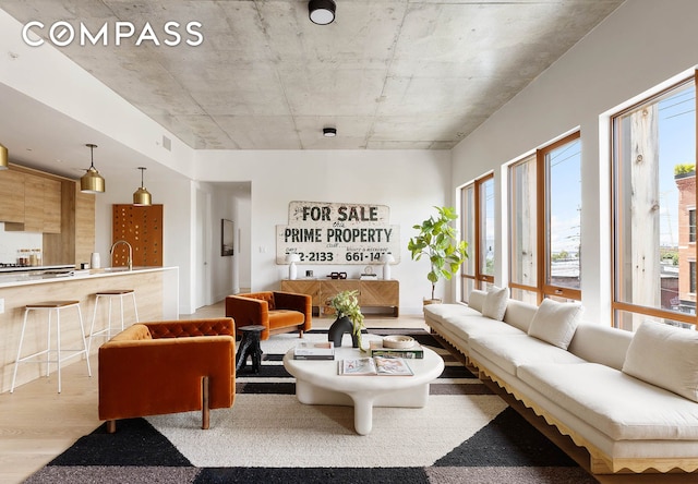 living area with wood finished floors, visible vents, and a healthy amount of sunlight