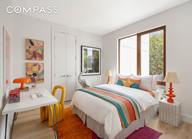 bedroom featuring baseboards, a closet, and light wood-style floors