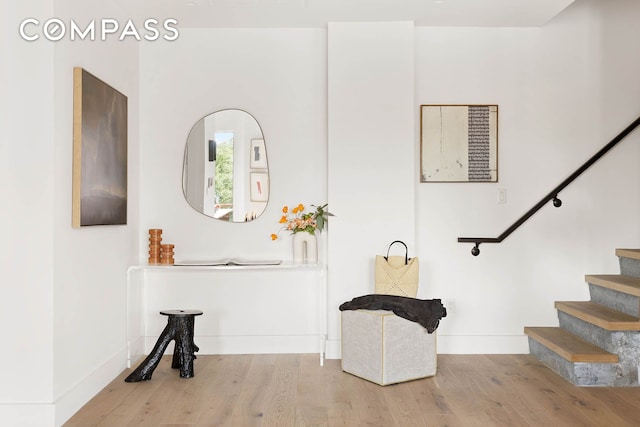 foyer with stairway, wood finished floors, and baseboards