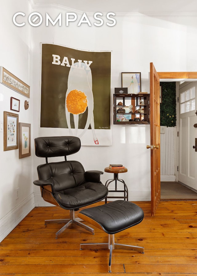 living area featuring baseboards and hardwood / wood-style flooring